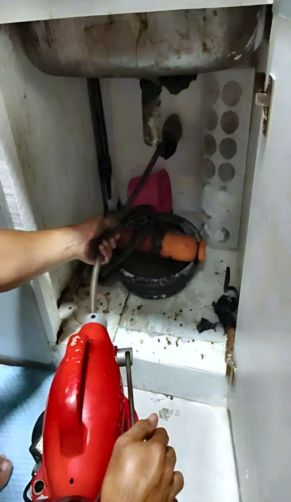 Malabanan P&M actual work: Barado na lababo, cleared — Declogging a kitchen sink by running the drain snake through the pipe under the lababo.